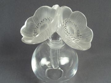 LALIQUE. Flacon en verre, bouchon en forme de fleurs.Signé. H. 17 cm
