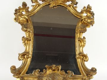 Miroir de style Louis XV en bois et stuc doré à décor de têtes d'amour