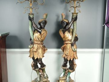 Paire de nubiens porte-torchères en bois polychrome et tôle dorée. H. 