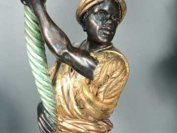 Paire de nubiens porte-torchères en bois polychrome et tôle dorée. H. 