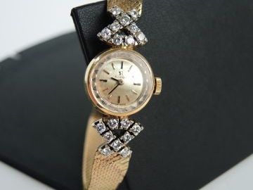 OMEGA. Montre bracelet et boitier en or, orné de brillants. Poids tel 