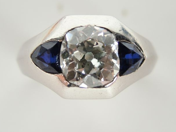 Bague en platine de forme chevalière, sertie d’un diamant taille couss