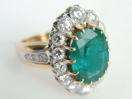 Bague marguerite ornée au centre d'une émeraude ovale de 3 carats envi