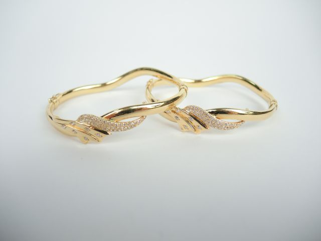 Paire de bracelets en or, forme chantournée, orné de petites roses. Po