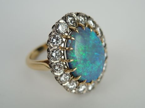 Bague marguerite ornée d'une belle opale doublet sur onyx, entourage d
