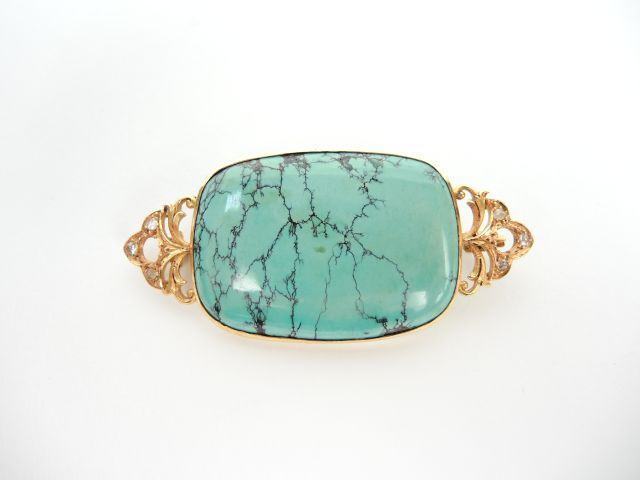 Broche en or ornée d'une turquoise et  de petites roses. Poids tel. 18