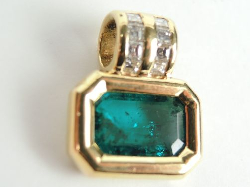 Pendentif serti  d'une émeraude, monture en or, bélière soulignée de d