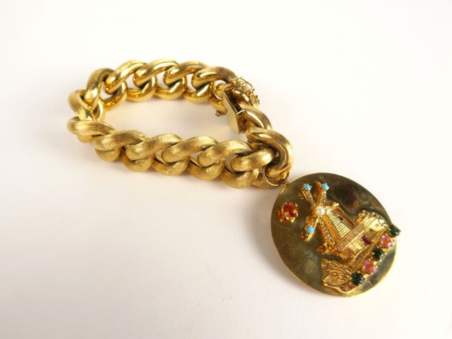 Bracelet en or 14 carats, mailles brossées, retenant un grand médaillo