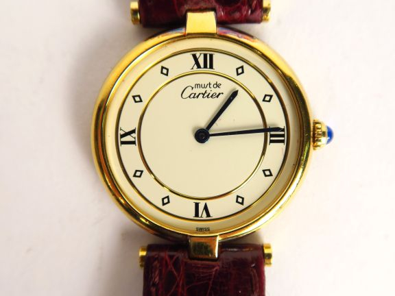CARTIER.  Montre, modèle Must, cadran en vermeil, bracelet en cuir. Ma