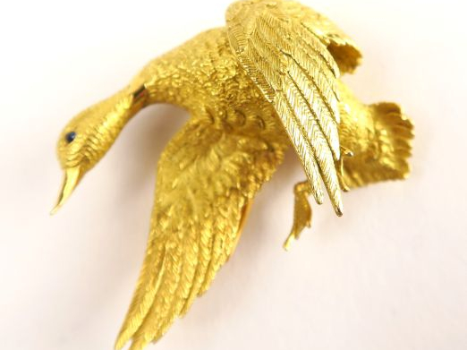 HERMES. Broche en or figurant un canard en vol, œil en cabochon de sap