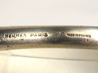 HERMES. Bracelet jonc en métal argenté, à décor de deux têtes de cheva