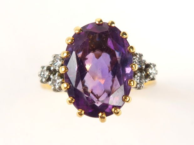 Bague en or jaune, sertie d'une améthyste de forme ovale, épaulée de 3