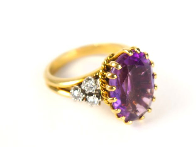 Bague en or jaune, sertie d'une améthyste de forme ovale, épaulée de 3