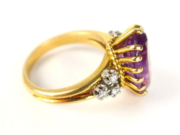 Bague en or jaune, sertie d'une améthyste de forme ovale, épaulée de 3