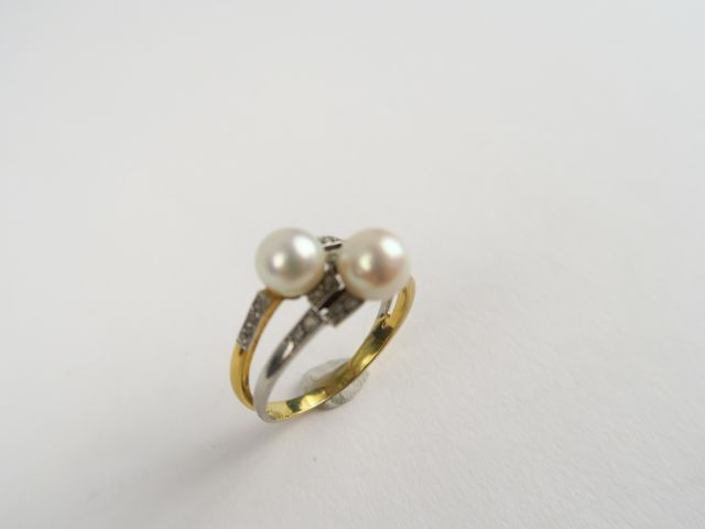 Bague en or et platine ornée de deux perles et de petites roses. Poids