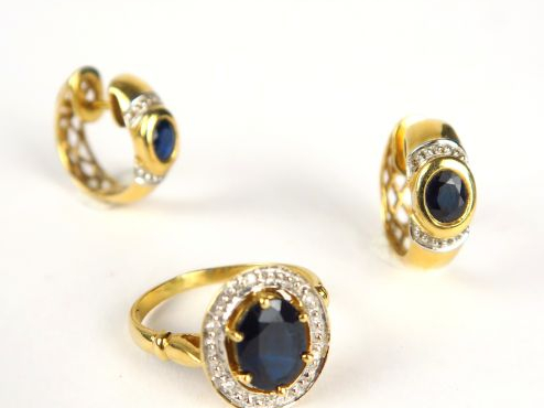 Bague et paire de perce-oreilles assortis ornés de saphirs. Monture en