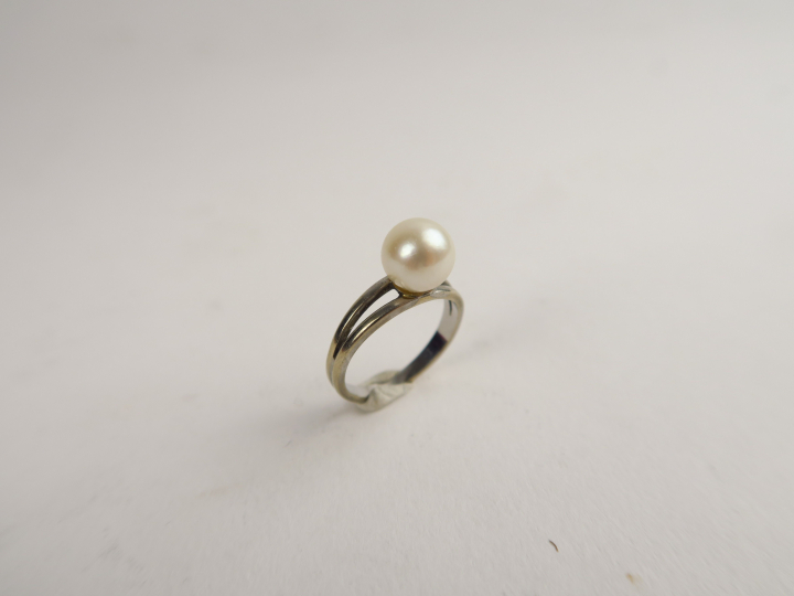 Bague ornée d'une perle de culture, monture en or blanc ajourée. Poids