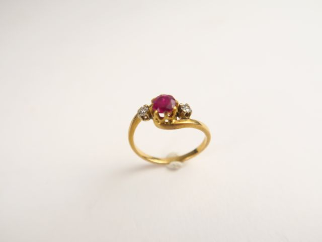 Bague en or sertie d'un rubis (traité) épaulé de deux petits diamants.