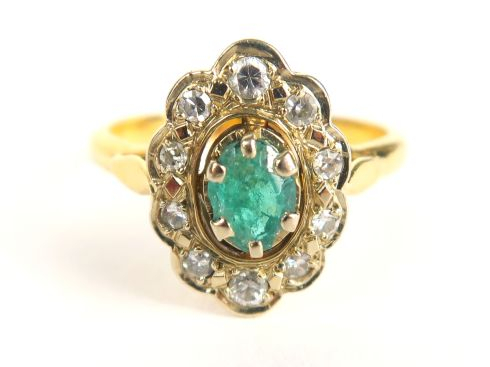 Bague en or jaune, sertie d'une émeraude dans un entourage de petits d