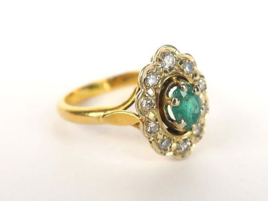 Bague en or jaune, sertie d'une émeraude dans un entourage de petits d