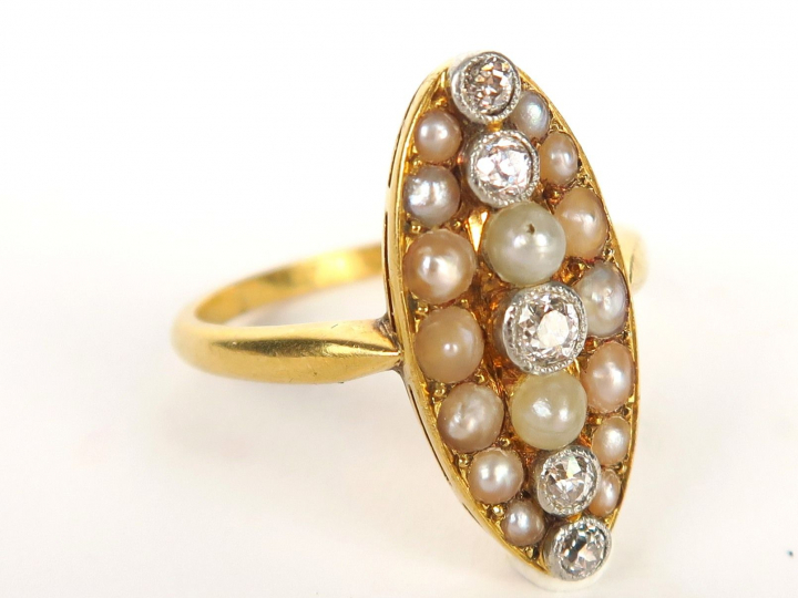 Bague marquise en or ornée de quatre diamants sertis clos, sur fond de