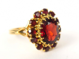 Vente aux enchères Bague marguerite en or jaune ornée de grenats. Poids tel : 5,43 g
