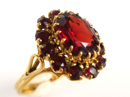 Bague marguerite en or jaune ornée de grenats. Poids tel : 5,43 g