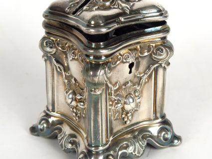 Tirelire en métal argenté à décor de guirlandes. (clé manquante). Poid