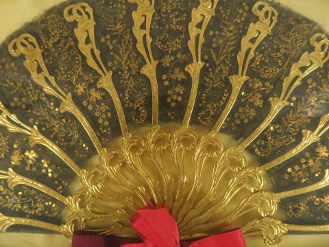 Eventail à feuilles pliées de style Louis XV, à décor noir et doré.  D