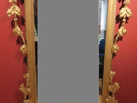 Grande glace de style Louis XVI en bois et stuc doré, à décor d'aigles