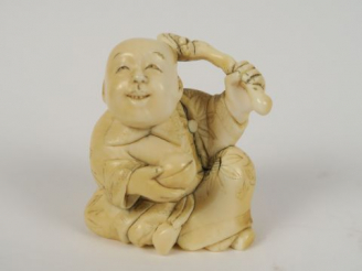 Vente aux enchères Okimono en ivoire représentant un caraco tenant une pêche et un lingzh