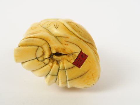 Okimono en ivoire représentant un caraco tenant une pêche et un lingzh