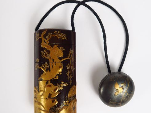 Inro à quatre cases, à décor au laque or sur fond ro iro d'un daim fra