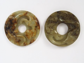 Vente aux enchères Deux disques bi en jade céladon et jade blanc veiné de rouille, sculpt