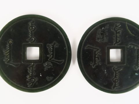 Deux disques bi en jade épinard, à décor de quatre idéogrammes sur cha