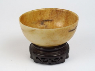 Vente aux enchères Coupe en jade beige légèrement veiné de rouille, sur socle.  Chine, dy