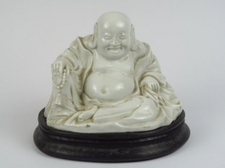 Vente aux enchères Sujet en porcelaine blanche figurant un bouddha souriant.  Chine, XX è