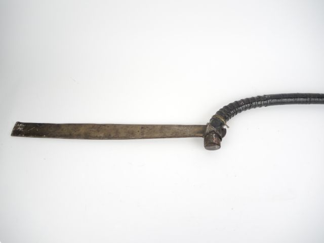 E.	 Forte arme d'hast, lame plate tranchant interne, manche bois corde