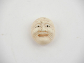 Vente aux enchères Netsuké en ivoire du Japon fin XIXème début XXème figurant un masque d
