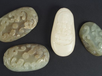 Vente aux enchères Lot de quatre pendentifs ou éléments en jade ou serpentine, à décor de