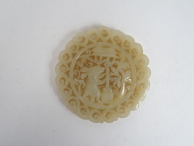 Pendentif de forme circulaire en jade céladon, décor ajouré d'un lapin