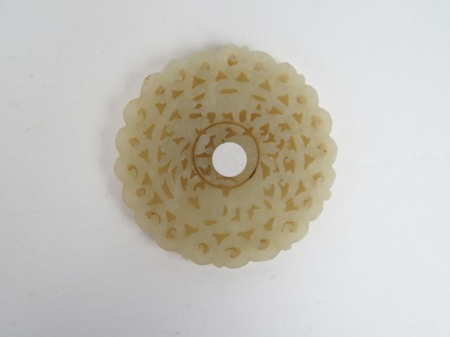 Pendentif de forme circulaire en jade céladon, décor ajouré d'un lapin