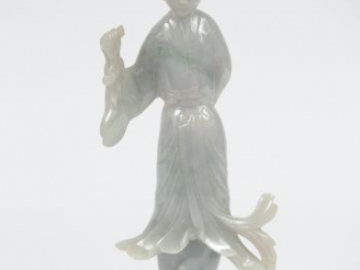 Vente aux enchères Statuette en jadéïte représentant une jeune femme tenant un lingzheu. 