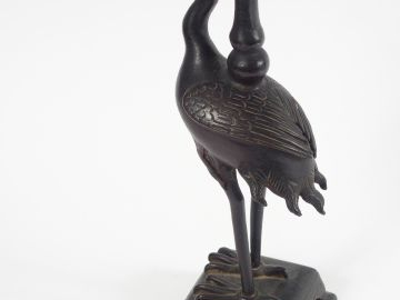 Porte-cierge en bronze à patine brune, figurant un échassier supportan