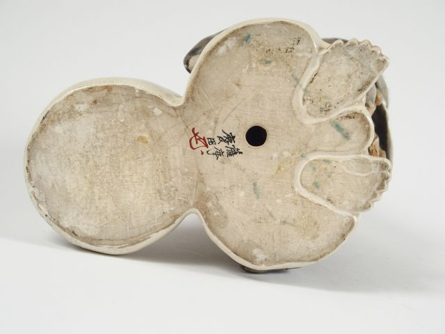 Statuette en faïence de statzuma représentant Ohteï debout tenant dans