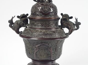 Brûle-parfum tripode en bronze à patine brun-rouge, à décor de fleurs,