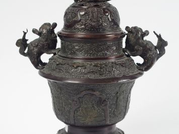 Brûle-parfum tripode en bronze à patine brun-rouge, à décor de fleurs,