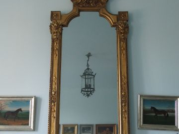 Grande glace de style Louis XVI en bois et stuc doré à décor de laurie