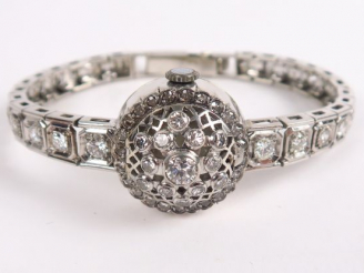 Vente aux enchères GERALDY. Montre bracelet à  en or blanc et platine, bracelet et couver