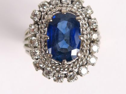 Bague ornée d'un saphir dans un entourage de petits diamants taille an